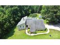 Aerial view of home surrounded by a landscaped yard, mature trees and a backdrop of lush greenery at 1769 Old Nc 27 Hwy, Mount Holly, NC 28120