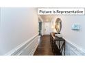 Light-filled hallway with wood floors and elegant wainscoting at 2019 Canvasback Way, Indian Trail, NC 28079
