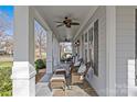 Spacious front porch showcasing rocking chairs, side tables, a ceiling fan, and elegant stone flooring, perfect for relaxing at 228 Heathwood Rd, Charlotte, NC 28211