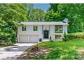 Charming split-level home featuring a two-car garage and updated black trim windows, nestled in a lush, green setting at 6726 Wannamaker Ln, Charlotte, NC 28226
