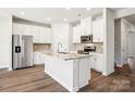 Modern kitchen with stainless steel appliances, white cabinets, and a large island at 115 Obadiah Ct, Troutman, NC 28115