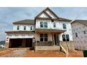 Unfinished two-story home with an attached two car garage and a covered front porch at 13312 Chopin Ridge Rd, Huntersville, NC 28078