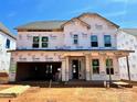 New construction home with a Tyvek wrapped exterior, showcasing a modern design and a two car garage at 13312 Chopin Ridge Rd, Huntersville, NC 28078