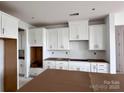 Spacious kitchen with white cabinets and modern design elements awaiting final touches at 13312 Chopin Ridge Rd, Huntersville, NC 28078