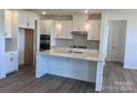 Bright kitchen boasts white cabinets, stainless appliances, pendant lights and spacious center island at 13312 Chopin Ridge Rd, Huntersville, NC 28078