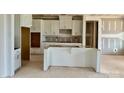 Unfinished kitchen with white cabinets and an island, ready to be completed at 13312 Chopin Ridge Rd, Huntersville, NC 28078
