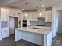 Bright kitchen features white cabinets, stainless appliances, and a large island with pendant lighting at 13312 Chopin Ridge Rd, Huntersville, NC 28078