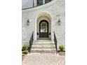 Stunning front entry with arched doorway, brick facade, and landscaping at 669 Dogwood Ln, Davidson, NC 28036