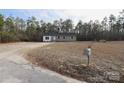 Wide shot of house with front yard, long driveway, and mailbox at 868 Monarch Pl, Kershaw, SC 29067