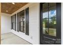 Covered front porch featuring wood ceiling, black door, and windows with black shutters at 2657 Polo Ln, Maiden, NC 28650