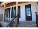 Charming front porch of a new home with wooden beams, brick base, and black framed windows at 2657 Polo Ln, Maiden, NC 28650