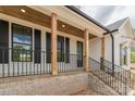 Charming front porch with brick base, wood columns, black railings, and ceiling with natural wood at 2657 Polo Ln, Maiden, NC 28650