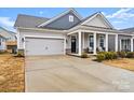 One story house with gray siding, two-car garage, and front porch at 111 N Shayna Rd, Troutman, NC 28166