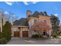 Two-car garage with wood doors and a brick and stone exterior at 2310 La Maison Dr, Charlotte, NC 28226