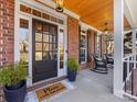 Inviting front porch with rocking chairs and brick columns at 353 Killian Ct, Matthews, NC 28104