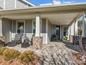 Brick columns and a stone patio enhance this charming front porch at 7145 Hanging Rock Ct, Denver, NC 28037