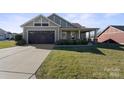Single-story home with attached garage and landscaped lawn at 1132 Cades Ct, Denver, NC 28037