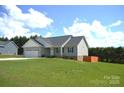 Single-story home with a side-entry garage, green lawn, and a fence defining the landscape at 118 Cypress Acres Ln, Statesville, NC 28625
