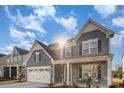 Two story gray house with white accents, landscaping, and a porch at 1844 Giana Ln, Monroe, NC 28112