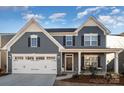 Two-story gray house with white accents, landscaping, and a porch at 1844 Giana Ln, Monroe, NC 28112