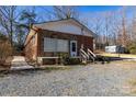 Cozy home featuring a stone and brick exterior with a gravel driveway and small yard at 206 Fox Den Rd, Troy, NC 27371
