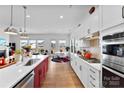 Modern kitchen featuring white cabinets, stainless steel appliances, large island, and open view to living area at 320 Northgate Blvd, Indian Trail, NC 28079