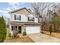 Two-story home showcasing stone accents and a two-car garage with landscaping at 6204 Springbeauty Dr, Charlotte, NC 28227