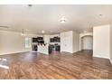 Spacious living room with hardwood floors, open floor plan, and a view into the kitchen at 6204 Springbeauty Dr, Charlotte, NC 28227