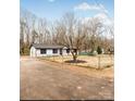 Ranch-style home with paved driveway and chain link fence at 375 Woodwedge Cir, Salisbury, NC 28144