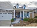 Inviting front porch with stone flooring and seating area at 517 Trillium Way, Belmont, NC 28012