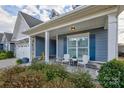 Relaxing front porch with white chairs and potted plants at 517 Trillium Way, Belmont, NC 28012