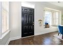 Welcoming entrance with hardwood floors and a black front door featuring transom window at 9182 Bonnie Briar Cir, Charlotte, NC 28277