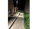 Backyard walkway and stairs leading to a deck at night, with stone and landscaping at 1422 Spring Ridge Ln, Denver, NC 28037