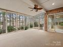 Enclosed sunroom offering panoramic views with brick accent wall, ceiling fan, and neutral carpeting at 4104 Granite Cir, Indian Land, SC 29707