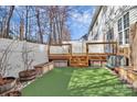 Artificial turf backyard with deck, raised garden beds, and white fence at 711 Torrey Pines Ln, Fort Mill, SC 29715