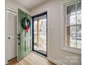 Bright entryway featuring a green front door, hardwood floors, and closet at 4328 Hancock Ter, Charlotte, NC 28205