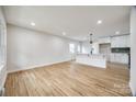 Open-concept living area with hardwood floors connecting to modern kitchen at 4328 Hancock Ter, Charlotte, NC 28205