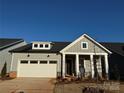 Gray Craftsman style home with a white garage door and landscaping at 7050 Wayfarer Dr # 0085, Charlotte, NC 28269