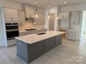 Modern kitchen with gray cabinets, white quartz island, and stainless steel appliances at 7050 Wayfarer Dr # 0085, Charlotte, NC 28269