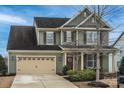 Two-story home with attached two car garage, covered front porch, and manicured landscaping at 17611 Austins Creek Dr, Charlotte, NC 28278