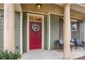 Inviting front porch with comfortable seating and a vibrant red front door, adorned with a floral wreath at 17611 Austins Creek Dr, Charlotte, NC 28278