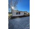 White mobile home with a gravel driveway and mature trees at 2379 Justin Dr, York, SC 29745