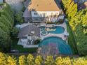 Expansive backyard featuring a luxurious pool, spa, basketball court, and outdoor entertaining area at 3042 Kings Manor Dr, Weddington, NC 28104