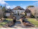 Grand home with manicured landscaping and a welcoming brick walkway to the front entrance at 3042 Kings Manor Dr, Weddington, NC 28104