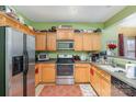 Kitchen with wood cabinets, stainless steel appliances, and green walls at 5927 Pisgah Way, Charlotte, NC 28217