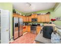 Kitchen with wood cabinets, stainless steel appliances, and green walls at 5927 Pisgah Way, Charlotte, NC 28217