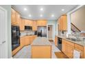 Bright kitchen with light wood cabinets, stainless steel appliances, granite countertops, and a functional center island at 3613 Savannah Way, Monroe, NC 28110