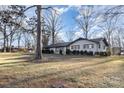 Brick ranch house with dark trim and a large yard, side view at 605 Impala Dr, Albemarle, NC 28001