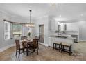 Bright eat-in kitchen with white cabinets, stainless steel appliances, and tile flooring at 663 Chadbourne Nw Ave, Concord, NC 28027