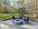 Inviting backyard firepit with stone surround, comfortable seating, and expansive lawn for outdoor enjoyment at 250 Kenway Loop, Mooresville, NC 28117